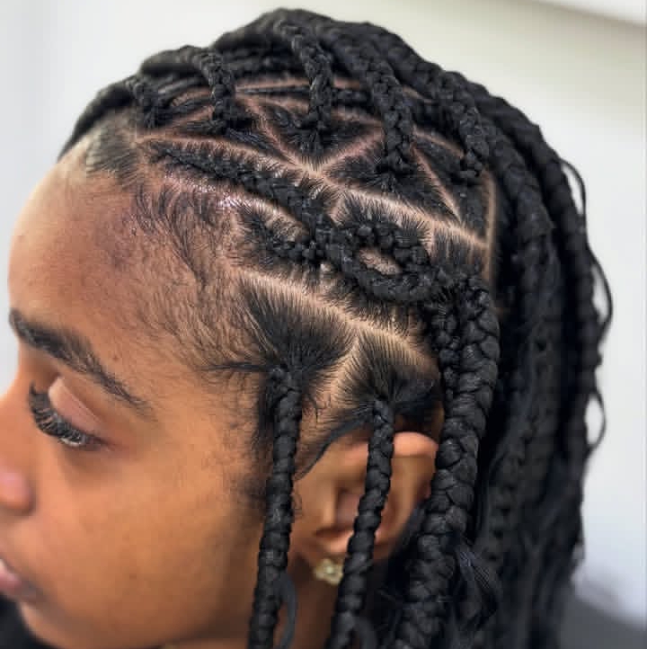 Close-up of a person's head showcasing a flip-over Fulani braids hairstyle with intricate cornrow designs.
